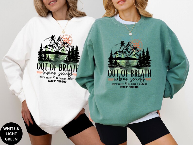 May include: White and light green sweatshirts with a mountain scene and the text "Out of Breath Hiking Society" with the year 1989 or 1990.