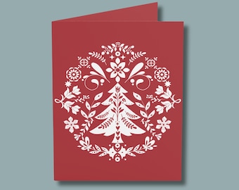 May include: A red card with a white stylized Christmas tree design. The tree is surrounded by a wreath of white flowers and leaves.