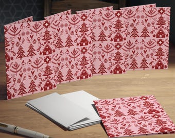 May include: A set of eight pink Christmas cards with a red Scandinavian-style pattern of trees, houses, and ornaments.