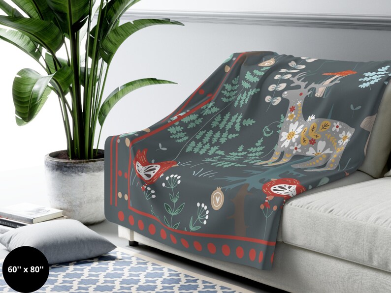 May include: A soft, gray fleece throw blanket with a colorful woodland design featuring a deer, birds, and flowers. The blanket is 60 inches by 80 inches.