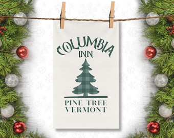 May include: A white tea towel with a green and white plaid pine tree design. The text "Columbia Inn Pine Tree Vermont" is printed below the tree.