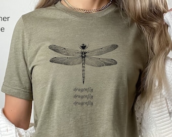 May include: A heather olive t-shirt with a black and white dragonfly graphic and the text "dragonfly dragonfly dragonfly" printed on the front.