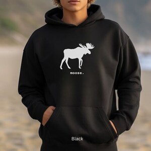 Adult unisex hooded sweatshirt with a graphic of a moose profile above the word moose in lower case font, followed by a period. Shown in Black.