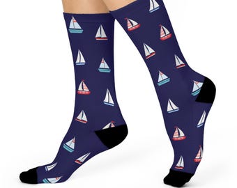 May include: A pair of blue socks with a white sailboat pattern. The sailboats have red and blue accents.