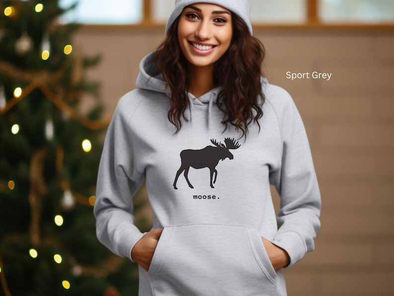 Adult unisex hooded sweatshirt with a graphic of a moose profile above the word moose in lower case font, followed by a period. Shown in Sport Grey.