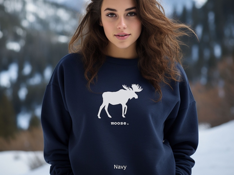 Adult unisex crewneck sweatshirt with a graphic of a moose profile above the word moose in lower case font, followed by a period. Shown in Navy.