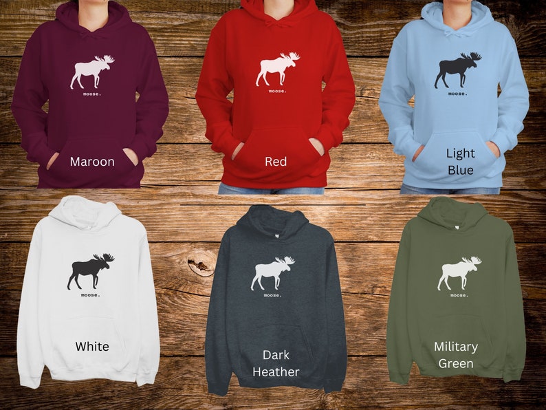 May include: Six different color hoodies with a white moose silhouette and the word "MOOSE..." printed on the front. The colors are maroon, red, light blue, white, dark heather, and military green.