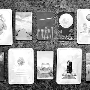 May include: A set of ten black and white tarot cards with various illustrations. The cards are arranged in two rows of five. The cards feature images of a mushroom, a mountain, a shooting star, a full moon, a planet, a dandelion, a staircase, a cup, a stone pillar, and a row of cups.
