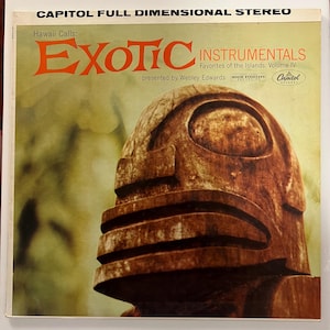 May include: Vintage vinyl record album cover titled "Exotic Instrumentals" featuring a wooden tiki statue. The album is part of the "Hawaii Calls" series, presented by Webley Edwards. The Capitol Records album cover has a retro design.