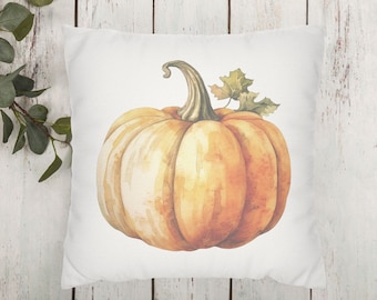 May include: A white pillow with a watercolor illustration of a single orange pumpkin with a green stem and leaf. The pumpkin is centered on the pillow.