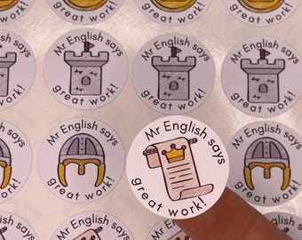 May include: A collection of round stickers with the text "Mr. English says great work!" and various illustrations, including a crown, a castle, a helmet, and a scroll with a crown. The stickers are white with black and yellow accents.