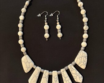 White howlite beaded statement necklace,  silvery accent beads and lobster claw clasp. Matching dangle earrings with silver-colored hooks