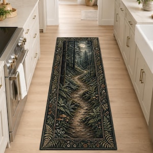 Puede incluir: Una alfombra rectangular con un diseño de bosque con un camino sinuoso, helechos y árboles. La alfombra tiene un borde oscuro con detalles florales y de hojas. La paleta de colores incluye verdes, marrones y un toque de luz del cielo.