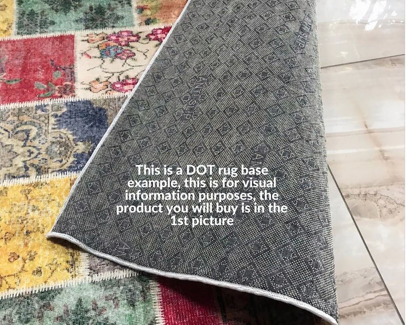 May include: A patchwork rug featuring a variety of colorful floral and ornate patterns in red, yellow, blue, and green. The underside of the rug is visible, showing a dark gray anti-slip backing with a repeating dot and diamond texture pattern.