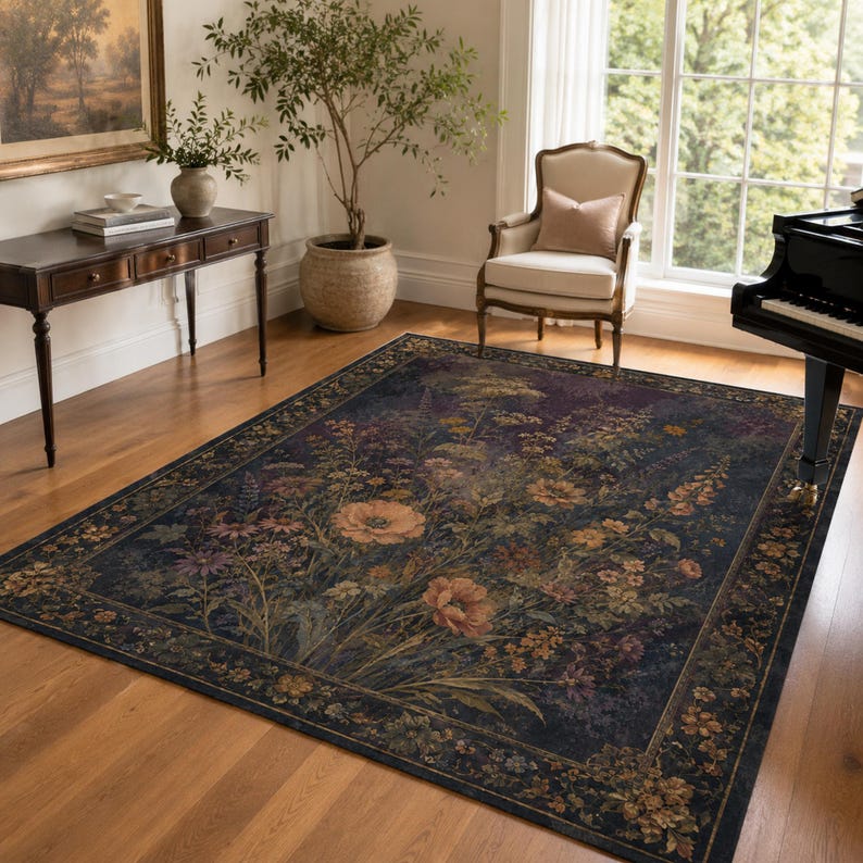 May include: A rectangular area rug featuring a dark navy blue background with a central botanical print of orange, yellow, and purple wildflowers. The rug has a wide, ornate border decorated with a repeating floral pattern in muted earth tones.