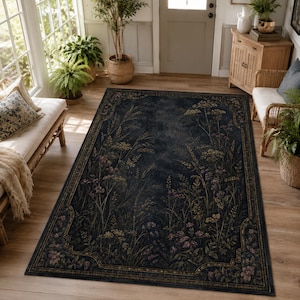May include: A rectangular area rug featuring a dark navy blue background with a detailed botanical print of wildflowers, grasses, and foliage in muted tones of green, purple, and gold, enclosed by a decorative border with a repeating floral pattern.
