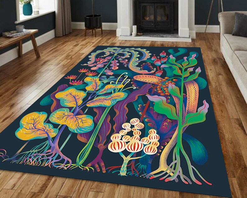 May include: A colorful rug with a dark blue background featuring a stylized design of various plants and flowers. The plants are in shades of yellow, green, red, and purple.