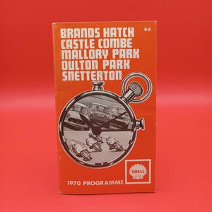 Puede incluir: Una guía de programa vintage de la década de 1970 para carreras de motocicletas en Brands Hatch, Castle Combe, Mallory Park, Oulton Park y Snetterton. La portada presenta una foto en blanco y negro de motocicletas compitiendo en una pista, con un logotipo de Shell en la esquina inferior derecha.