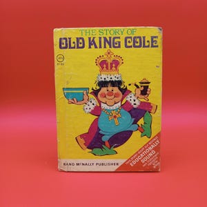 Puede incluir: Una cubierta de libro amarilla con el título "The Story of Old King Cole" en texto negro. La cubierta presenta una ilustración de dibujos animados de un rey con una corona, sosteniendo un tazón y una pipa. El libro es publicado por Rand McNally y es parte de la serie Start-Right Elf Books.