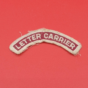 May include: A curved embroidered patch featuring the text LETTER CARRIER in white capital letters on a maroon background, bordered by a white stitched edge. The patch has a slightly frayed appearance along the outer white border stitching.