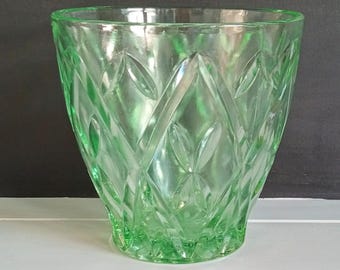 May include: A green glass vase with a diamond pattern. The vase is clear and has a textured surface.