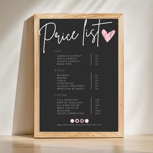 Könnte beinhalten: Eine gerahmte Preisliste für Friseurdienstleistungen. Das schwarze Schild im Tafelstil zeigt weißen handgeschriebenen Text mit einem rosa Herz. Zu den Dienstleistungen gehören Haarschnitte, Styling und Farbbehandlungen. Der Holzrahmen verleiht einen rustikalen Touch.