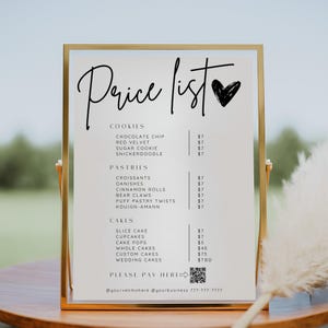 May include: A gold-framed sign displays a handwritten "Price list" with a heart graphic. The list includes cookies, pastries, and cakes with prices. The sign also includes a QR code and contact information.