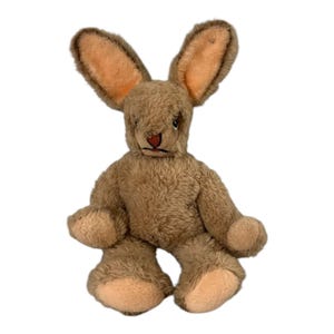 May include: A brown plush bunny rabbit with long ears and a stitched-on face. The bunny is sitting with its legs crossed.