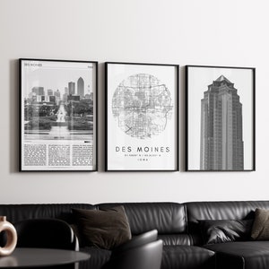 May include: Three black and white framed prints of Des Moines, Iowa. The first print shows a street scene with buildings in the background. The second print shows a circular map of the city. The third print shows a tall building.