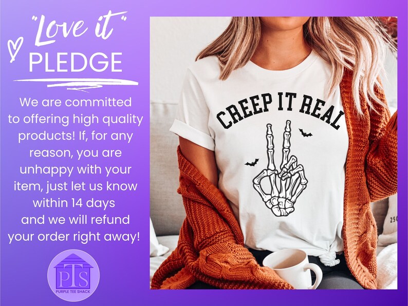 May include: White t-shirt with a black skeleton hand making a peace sign and the text "CREEP IT REAL" in black. The t-shirt is worn by a person with long brown hair and a brown cardigan.