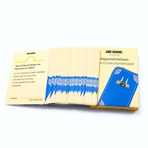 May include: A deck of Islamic trivia cards with a blue and yellow box. The box has the text "sabr season. live life with sabr" and "Allgemeinwissen islamisches Kartenspiel". The cards have questions about the prophet Musa (Moses) and his mother.