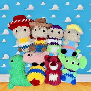 Puede incluir: Una colecci&oacute;n de juguetes de peluche tejidos a crochet inspirados en los personajes de la franquicia de pel&iacute;culas Toy Story. Los juguetes incluyen a Woody, Buzz Lightyear, Jessie, Rex, Hamm, Slinky Dog y un extraterrestre verde. Los juguetes est&aacute;n dispuestos en grupo sobre una superficie de madera.