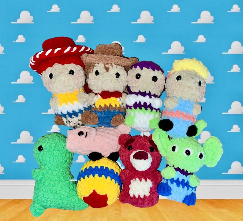Puede incluir: Una colecci&oacute;n de juguetes de peluche tejidos a crochet inspirados en los personajes de la franquicia de pel&iacute;culas Toy Story. Los juguetes incluyen a Woody, Buzz Lightyear, Jessie, Rex, Hamm, Slinky Dog y un extraterrestre verde. Los juguetes est&aacute;n dispuestos en grupo sobre una superficie de madera.