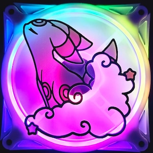 May include: A square computer fan with a colorful, rainbow-like LED light display. The fan features a cartoon illustration of a creature on a cloud with stars. The creature is pink and white with black outlines.