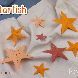 Könnte beinhalten: Ein Set aus sieben Papier-Seesternen in verschiedenen Orangetönen und Braun. Die Seesterne sind auf einem weißen Stoffhintergrund angeordnet. Der Text "Starfish" befindet sich oben im Bild und "SVG, PDF FILE" unten.