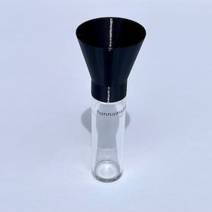 May include: A black plastic funnel attached to a clear glass bottle with the text "hannainst" on the label.
