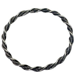 May include: A circular bangle bracelet crafted from polished silver-toned metal, featuring a continuous twisted rope design. The surface exhibits a textured, braided appearance with darkened recessed areas that highlight the intricate spiral pattern.