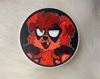 May include: A round sticker featuring a cartoon dog with red fur, black paws, and a black mask around its eyes. The dog has a mischievous expression with a slight grin and visible fangs. The sticker has a black border.