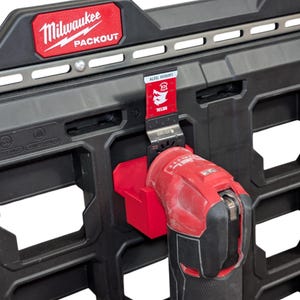 May include: A red and black Milwaukee PACKOUT storage system with a red oscillating multi-tool attached. A metal blade with "CARBIDE TEETH" is inserted into the tool. The Milwaukee logo is visible on the storage system.