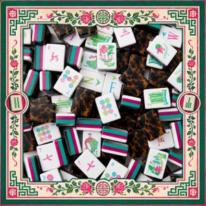 May include: A close-up of Mahjong tiles, featuring a mix of symbols, numbers, and the 'Joker' tile. The tiles are white, brown, and teal, set against a decorative border with floral and geometric designs. The game pieces are scattered.