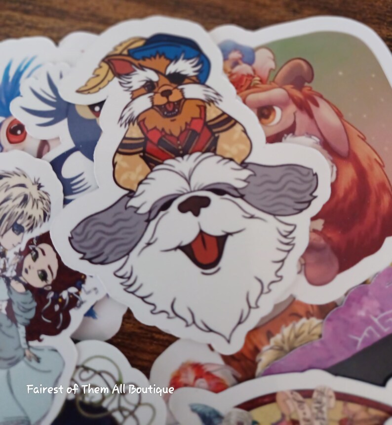 May include: A collection of colorful stickers featuring cartoon characters. The stickers include a smiling white dog with gray ears, a raccoon-like character in a red vest, and other animated figures. The stickers are on a wooden surface.