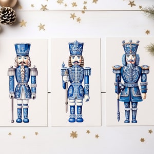May include: Three blue and white nutcracker figurines with gold accents. The nutcrackers are standing in a row on a white background.