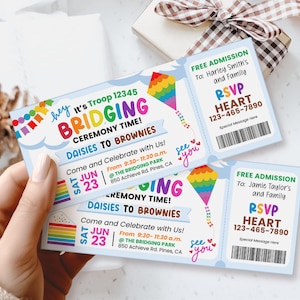 May include: A blue and white invitation card with a rainbow kite design. The text on the card reads "It's Troop 12345 Bridging Ceremony Time! Daisies to Brownies". The card also includes the date "Sat Jun 23" and the time "9:30-11:30 a.m.". The location is "The Bridging Park, 850 Achieve Rd. Pines, CA".