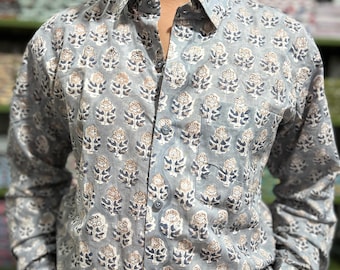 May include: A button-down shirt with a floral pattern in shades of gray, white, and brown. The long-sleeved shirt has a classic collar and a single chest pocket. The floral design is repeated across the fabric.