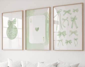 May include: Three framed prints with a green background. The left print features a green bow and a disco ball. The center print features a green ace of spades playing card. The right print features a collection of green bows.
