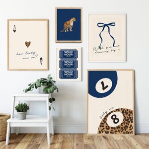 Op de afbeelding: Een set van zes ingelijste prints in een blauw en cr&egrave;me kleurenschema. De prints tonen een luipaard, een strik, een ticketstub, een biljartbal en een hart met de tekst "how lucky are we?" en "Wild, free hand dreaming big x".
