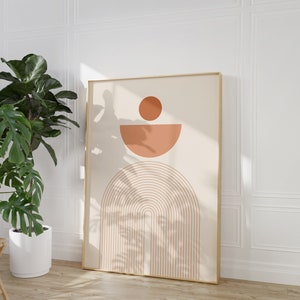 May include: A framed print with a minimalist geometric design featuring a peach-colored circle, half-circle, and a series of arches in a light brown color.