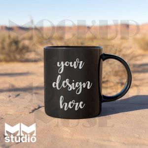 Puede incluir: Taza de cerámica negra con una inscripción blanca que dice "your design here" sobre una superficie arenosa.