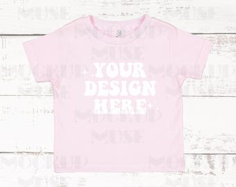 May include: A pink short-sleeved t-shirt with the text "YOUR DESIGN HERE" in white on the front.