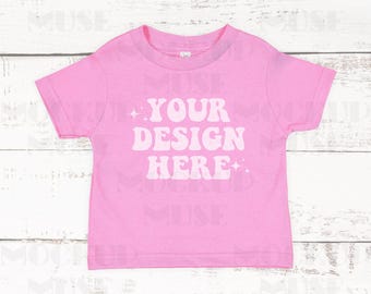 May include: Pink short-sleeved t-shirt with the text "YOUR DESIGN HERE" in white.